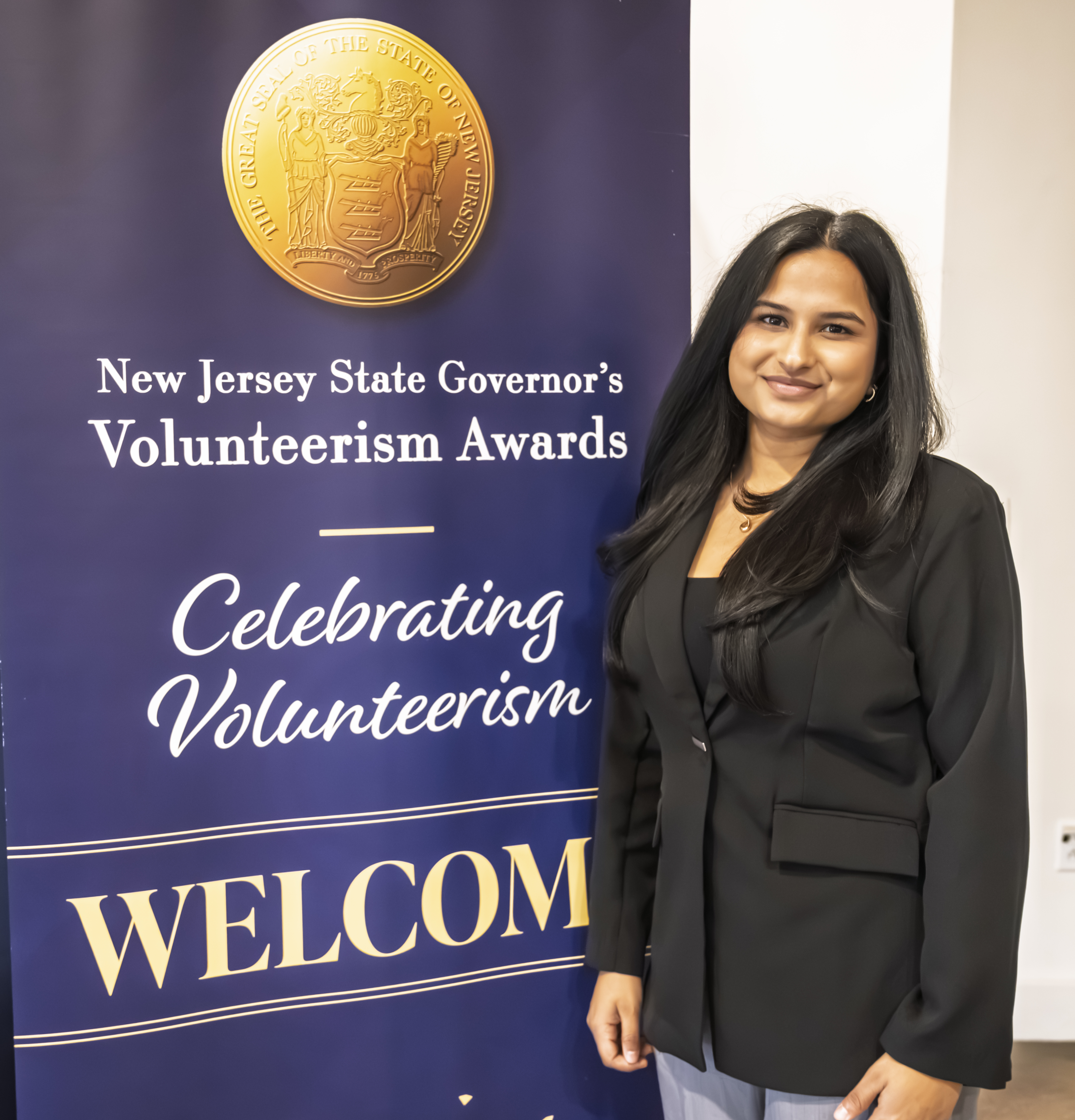 Simonee Shukla holding her award medal and certificate at the New Jersey State Governor's Volunteerism Awards